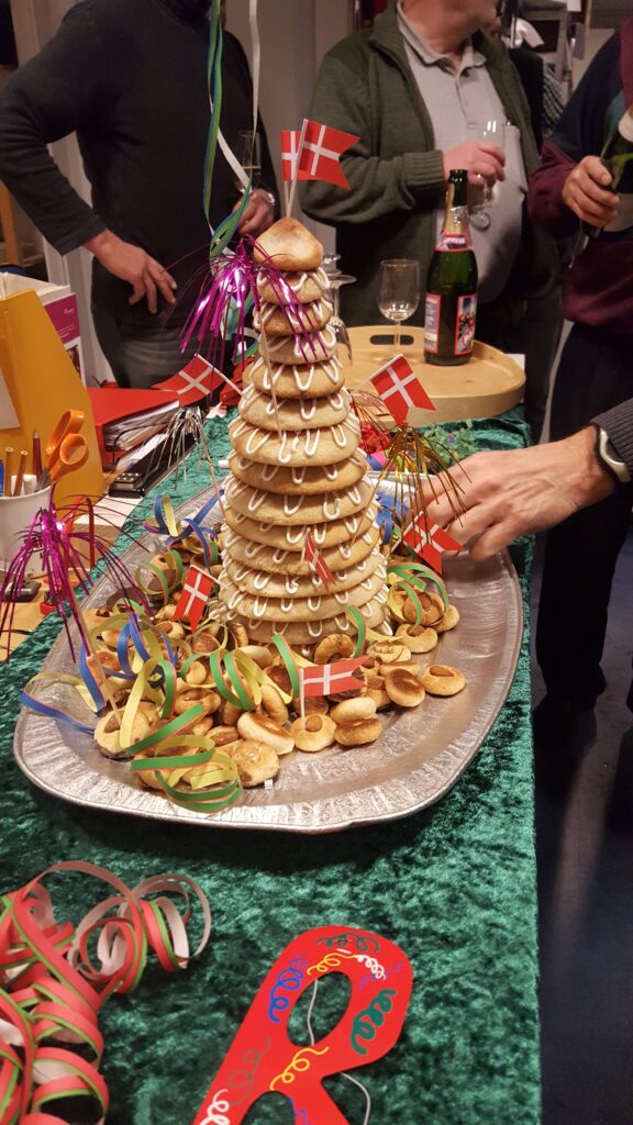 Der er en (Jens Ole) der er i gang med at tage noget af pynten omkring Heidis flytte kransekage.